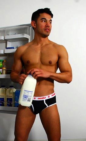 Muscle boy in underwear makes breakfast