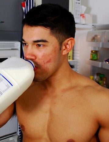 Dark haired jock drinks milk