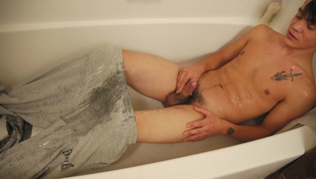 Hairless punk guy pisses on himself in the tub