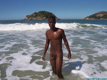 Young, lean black guy dripping wet in the surf
