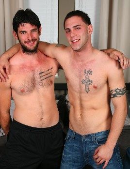Young tattooed punk and bearded guy embrace