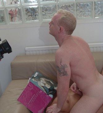 Jamie jerking off for the camera with a magazine covering Luc's face