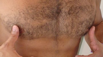 latin man with hairy chest plays with his nipples
