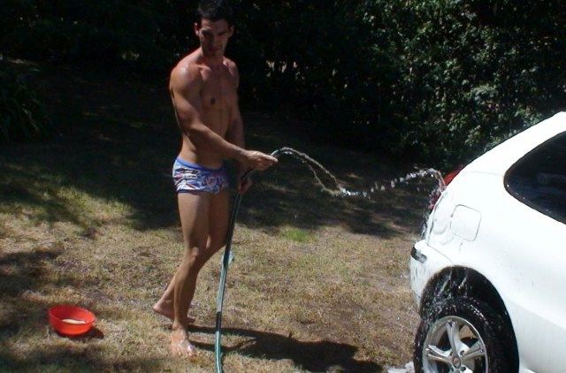Latino jock washing his car