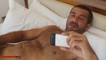 Hairy guy looks at the screen of his iPhone