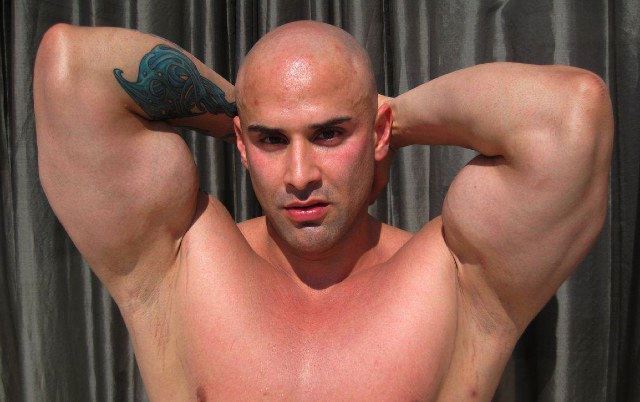 Bald bodybuilder shows huge biceps