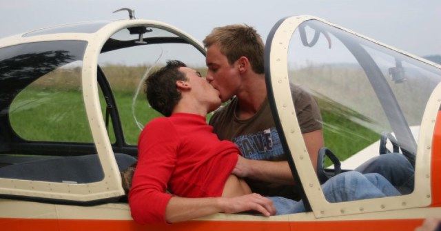 Two hot young guys kiss and feel each other up in a plane