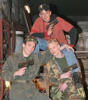 Three hot paintball jocks pose with their guns