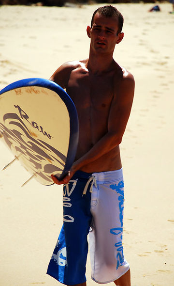 Skinny surfer with his board