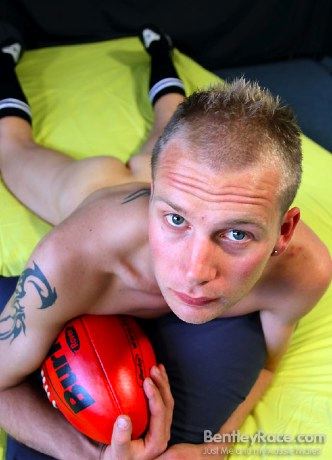 Athlete shows in a fuck me pose clutching his ball
