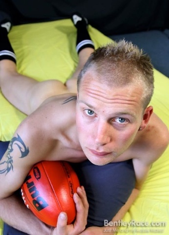 Athlete shows in a fuck me pose clutching his ball