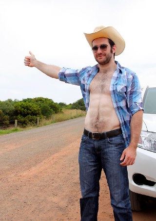 Hairy young cowboy hitchiking