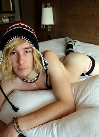 Cute young guy with long hair bare assed on the bed