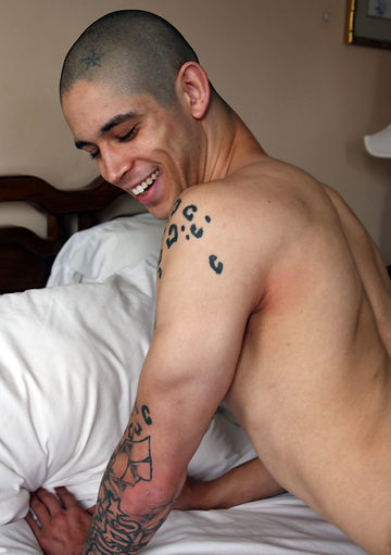 Inked jock shirtless on the bed