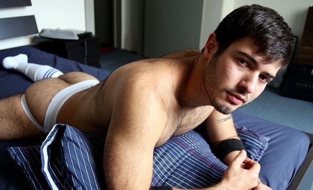 Alexander in a jock and socks on the bed