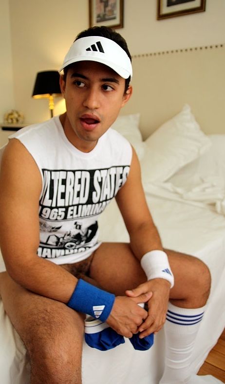 Paulo sits on the bed holding his underwear