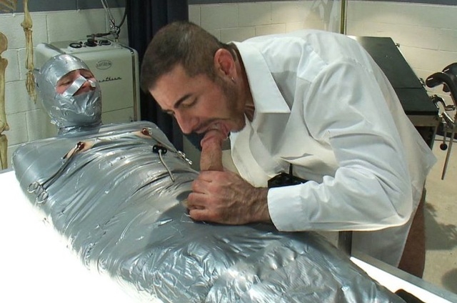 Nick teases the head of Jeof\'s cock while he is mummified with duct tape