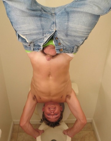 Shirtless Jeremiah Johnson does a handstand on the toilet