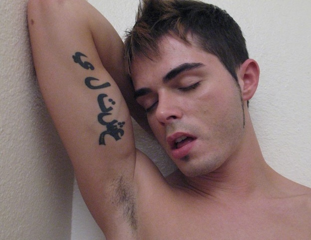 Tattood young guy shows armpit