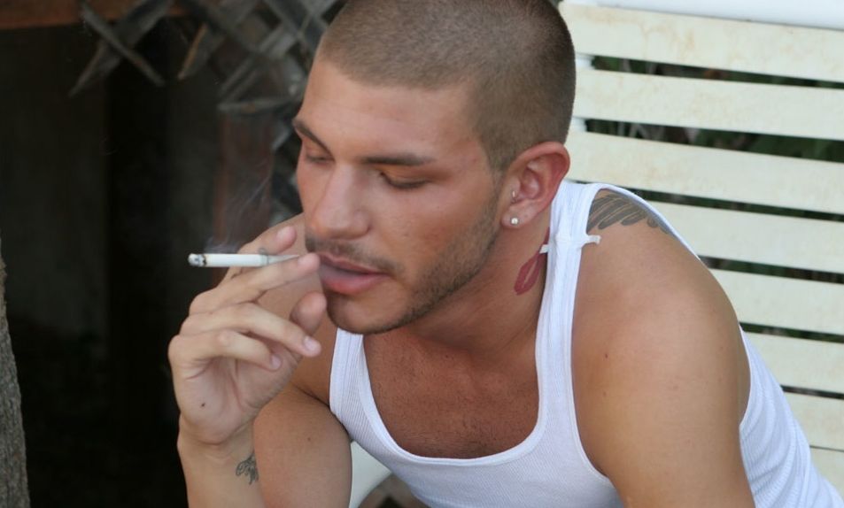 Inked Tristan Matthews takes a puff on his cigarette