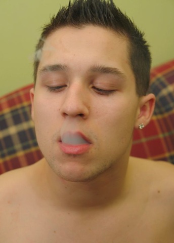 Beefy young guy exhaling smoke
