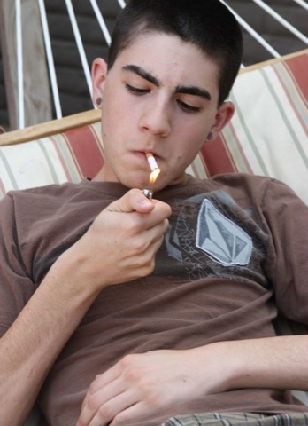 Young guy lighting cigarette