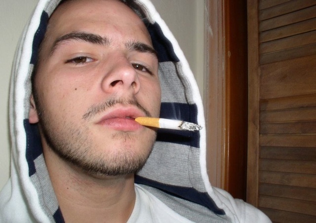 Face shot of white thug smoking.