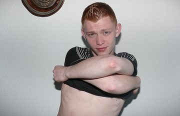 Red-headed teen taking off his shirt