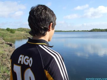 Pic from behind of teen looking otu over lake