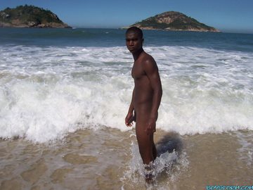 Young black guy naked at the ocean