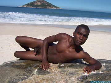 Young naked black guy at the ocean