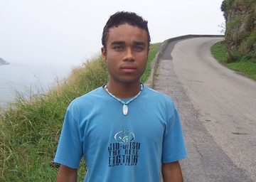 Teen by the road near the ocean