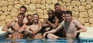 Eight guys hanging out naked in a pool