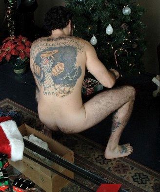 Hairy young guy with tattooes decorating the tree