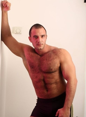 hairy body builder poses with smile