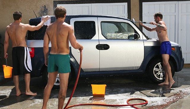 Three jocks wash a Honda Element