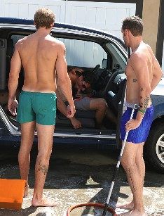 Two guys are sucking each other off in a car that's getting washed