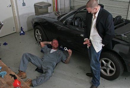 Auto Mechanic smiles as he watches customer in suit jack off