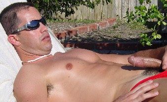 Stud plays with his cock and balls while basking in the sun