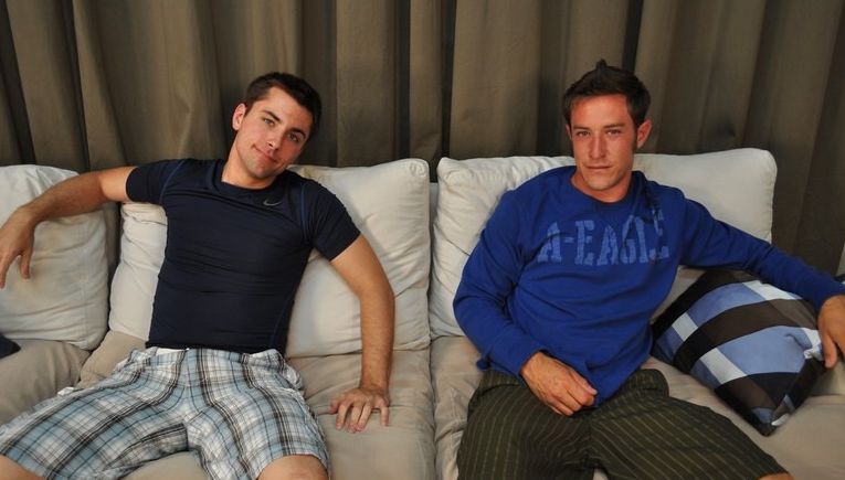 Two cute young jocks sitting on the couch