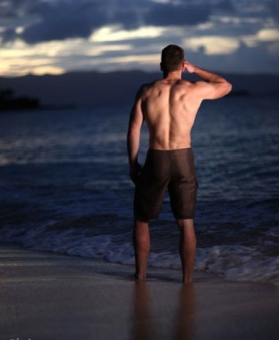 Muscled young guy shirtless on the beach
