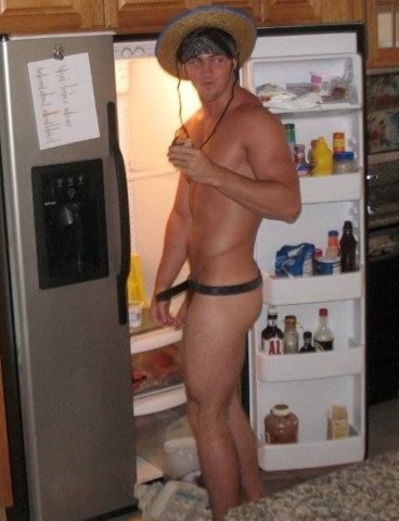 Naked frat boy getting some food out of the fridge