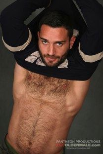 Hairy chested man pulling off sports jersey