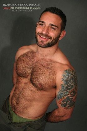 Hairy chested man with great smile and tattoo flashes some underwear