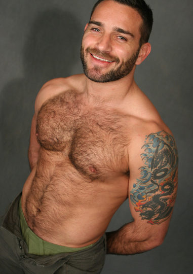 Hairy chested man with great smile and tattoo flashes some underwear