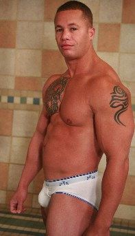 muscled jock with tats smiling
