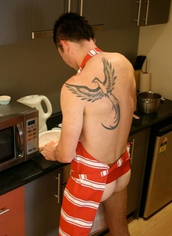 Inked guy cooking wearing only an apron