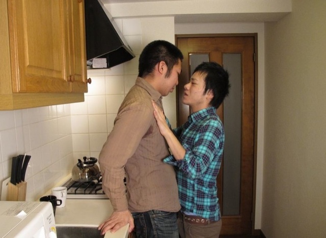 Two young guys getting friendly in the kitchen
