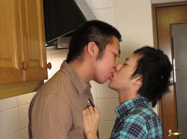Young guys kissing in the kitchen