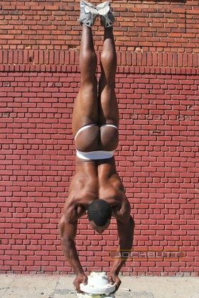 Young Black jock doing handstand in jockstrap